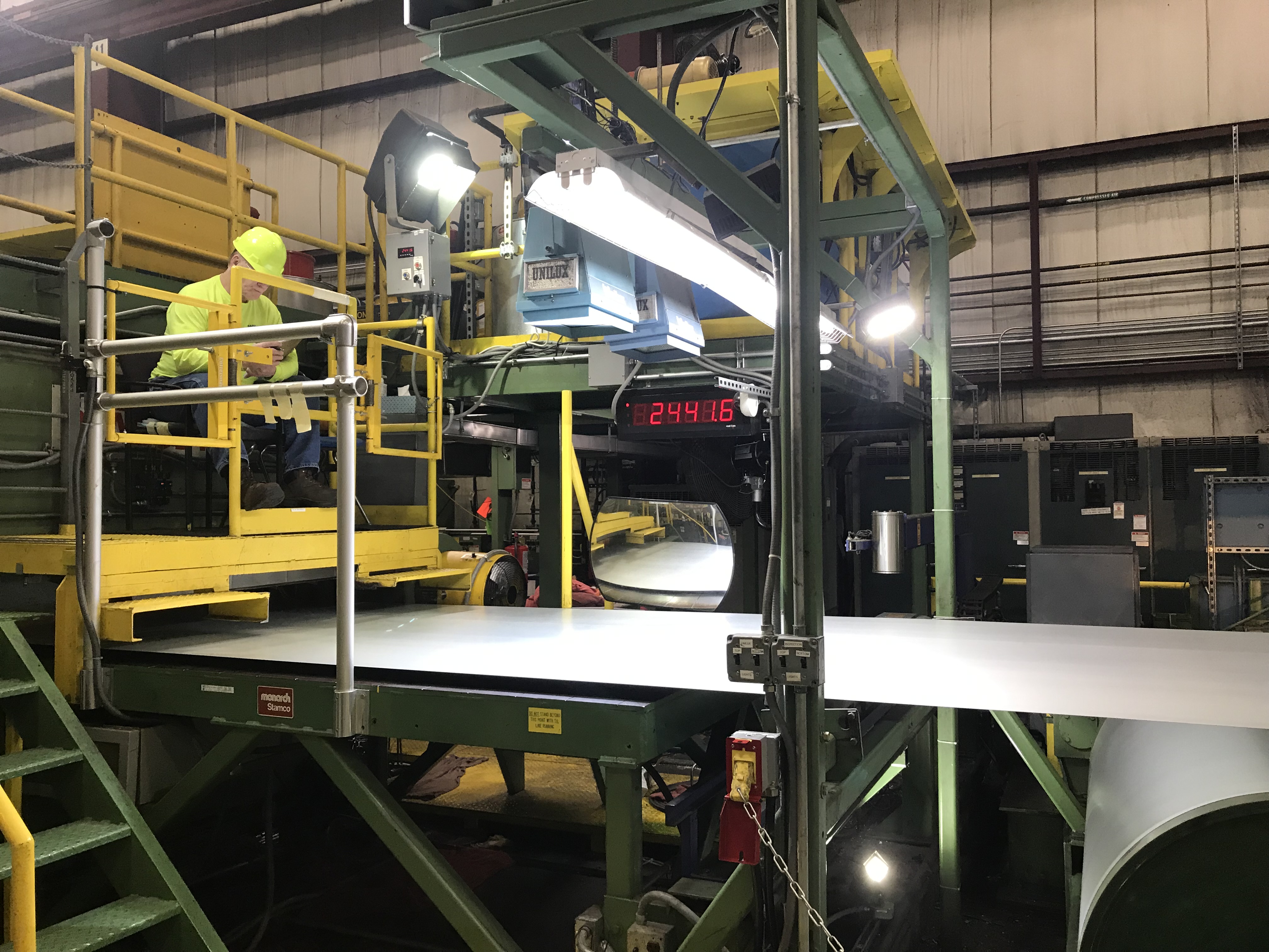 A Worthington steel employee performing a visual inspection after the flat rolled steel was tension leveled.